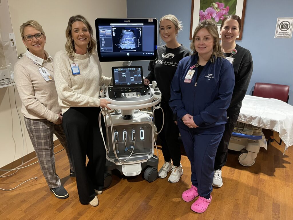 Five women standing by an ultrasound machine