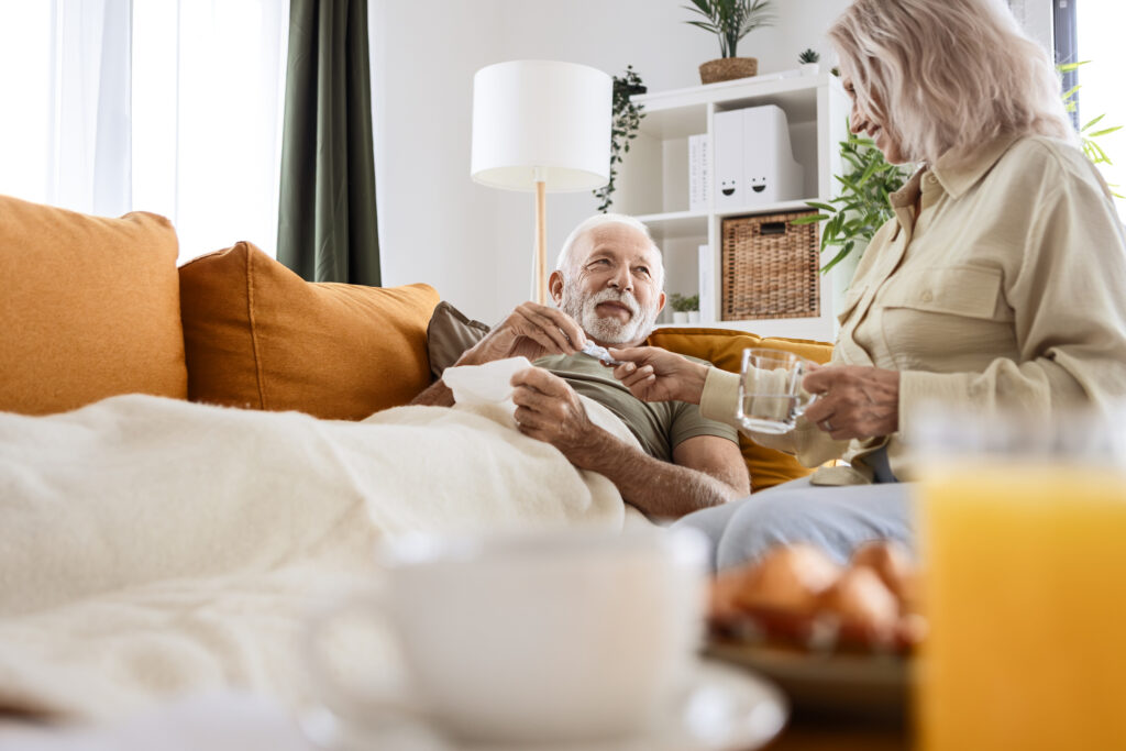A man laying on a couch and a woman sitting next to him.