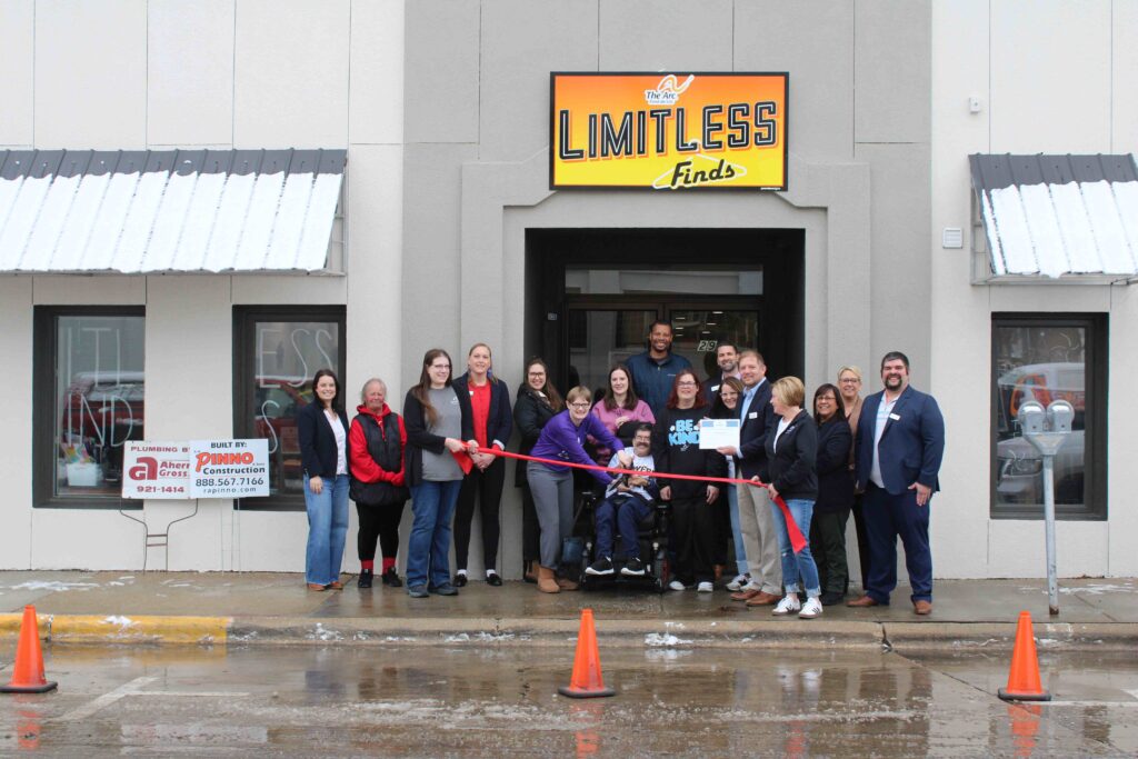 A group of people outside a building for a ribbon cutting