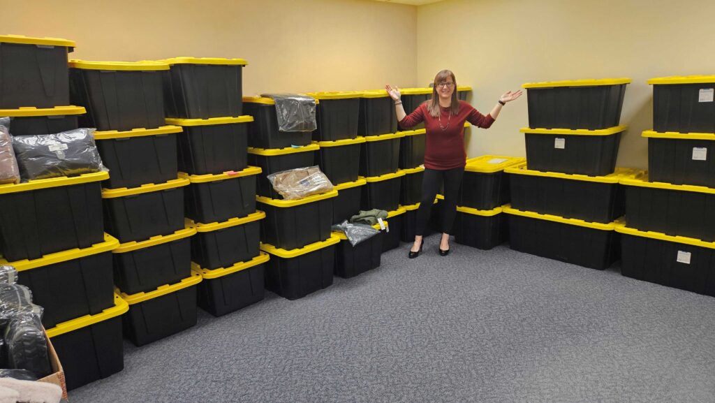 A woman in a room filled with storage bins