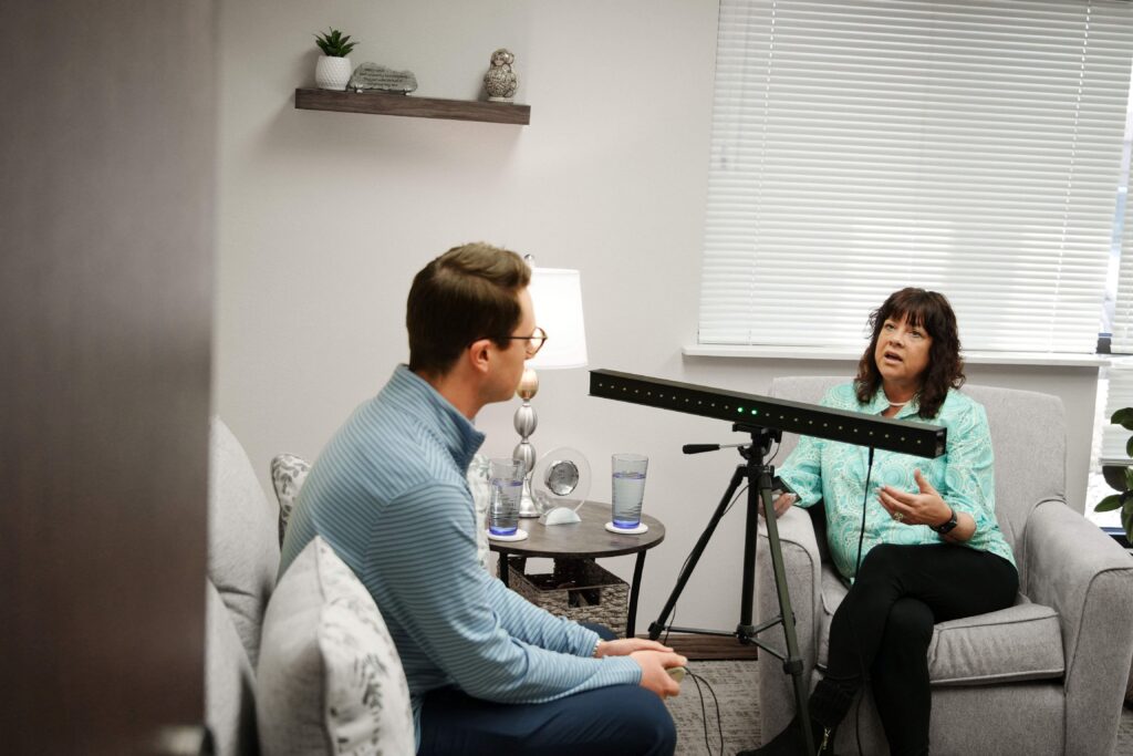 Two people sitting and talking with a piece of equipment in between them