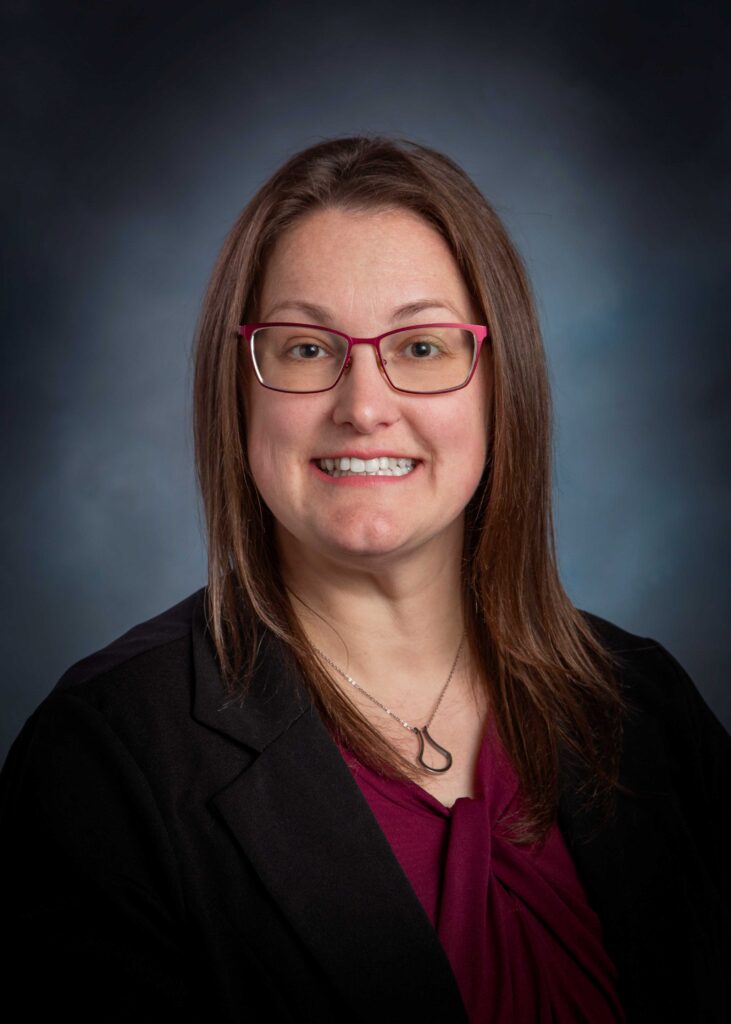 A smiling young woman with glasses