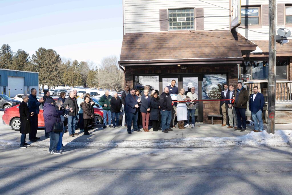 A large group of people outside for a ribbon cutting