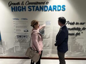 Two people in front of a wall of donor names