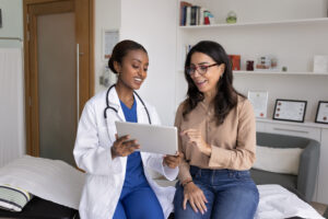 A doctor and a female patient look at papers