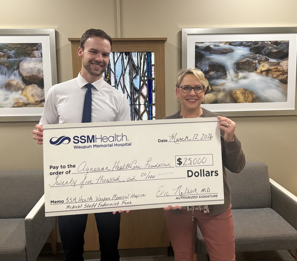 A man and a woman holding a big check