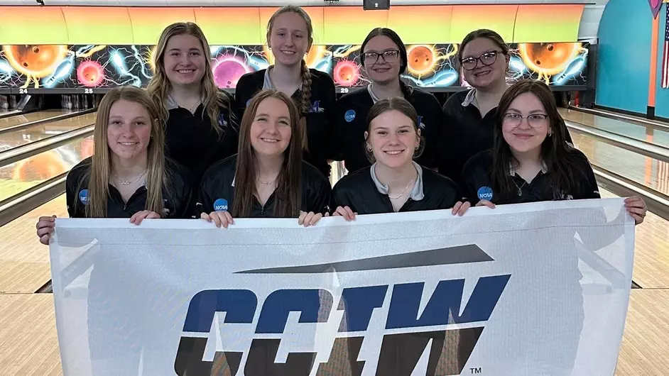 A female bowling team with a championship banner
