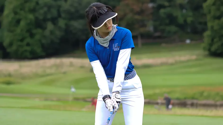 A woman playing colege golf