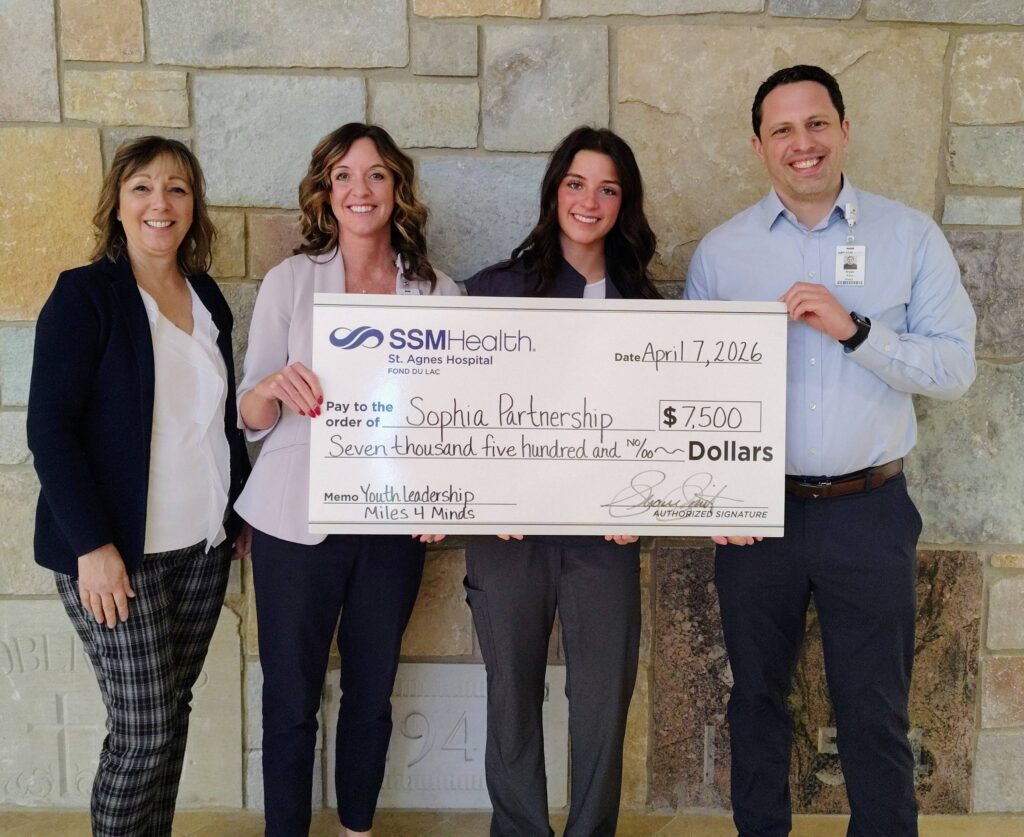 Four people with a big check