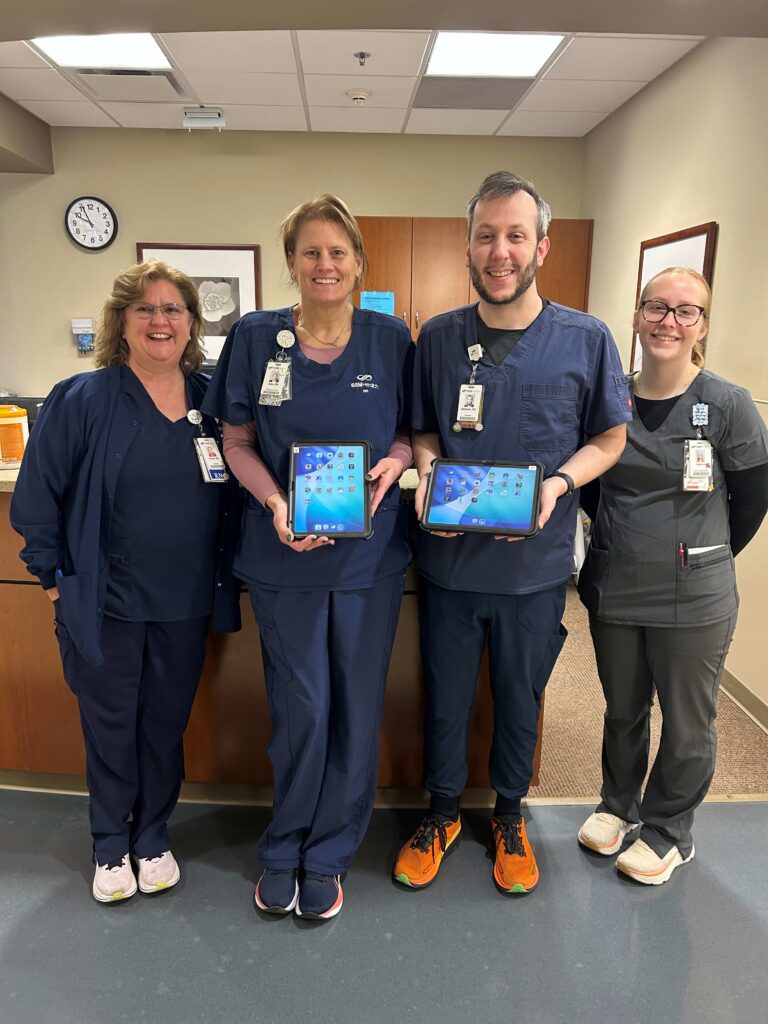 Four medical professionals holding ipads