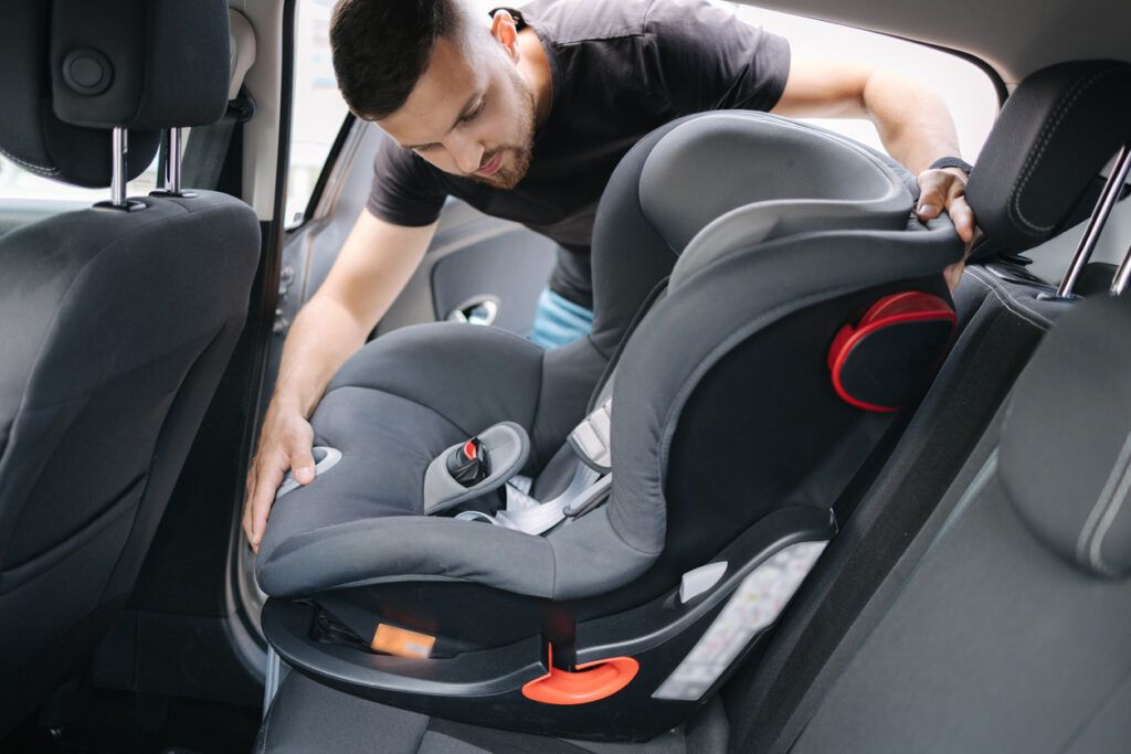 A man installing a car seat