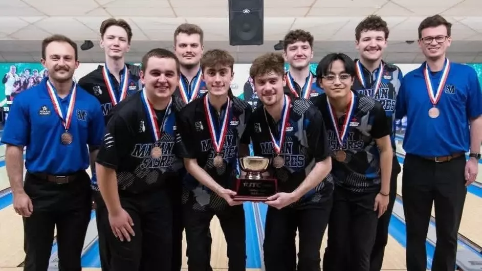 Men bowling for their college and the group is holding a trophy