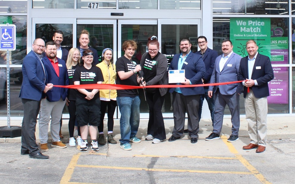 a large group of people outside for a ribbon cutting