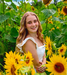 A smiling young woman in a field of sunflowers