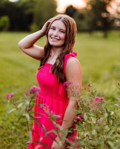 A smiling young woman in a field of flowers