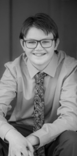 A smiling young man sitting down