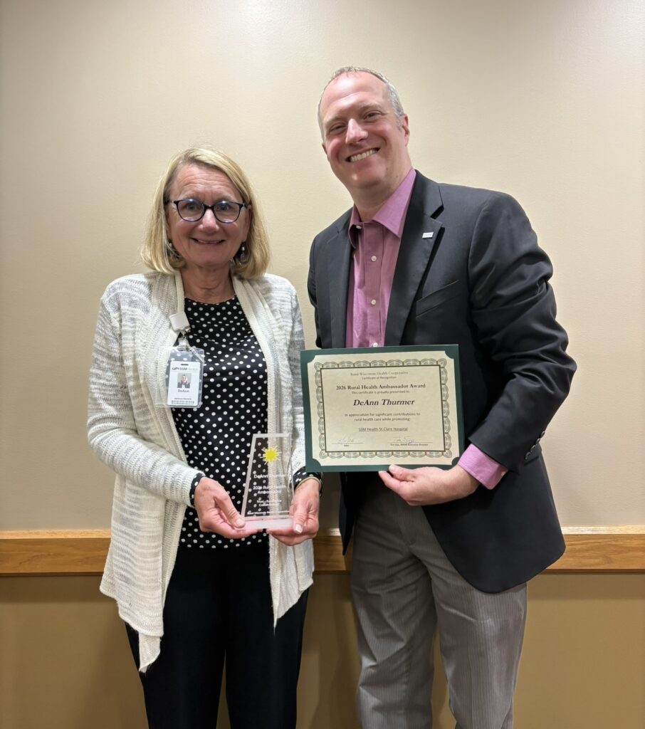 An older woman receiving an award from a man in a suit