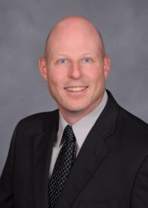 A middle aged man in a suit and tie