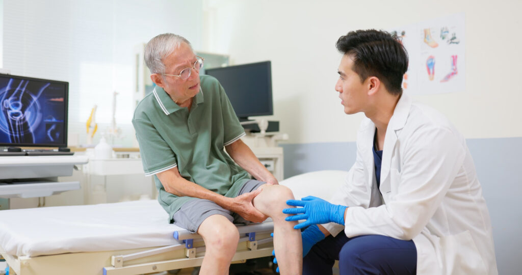 An older man sitting being treated by a doctor