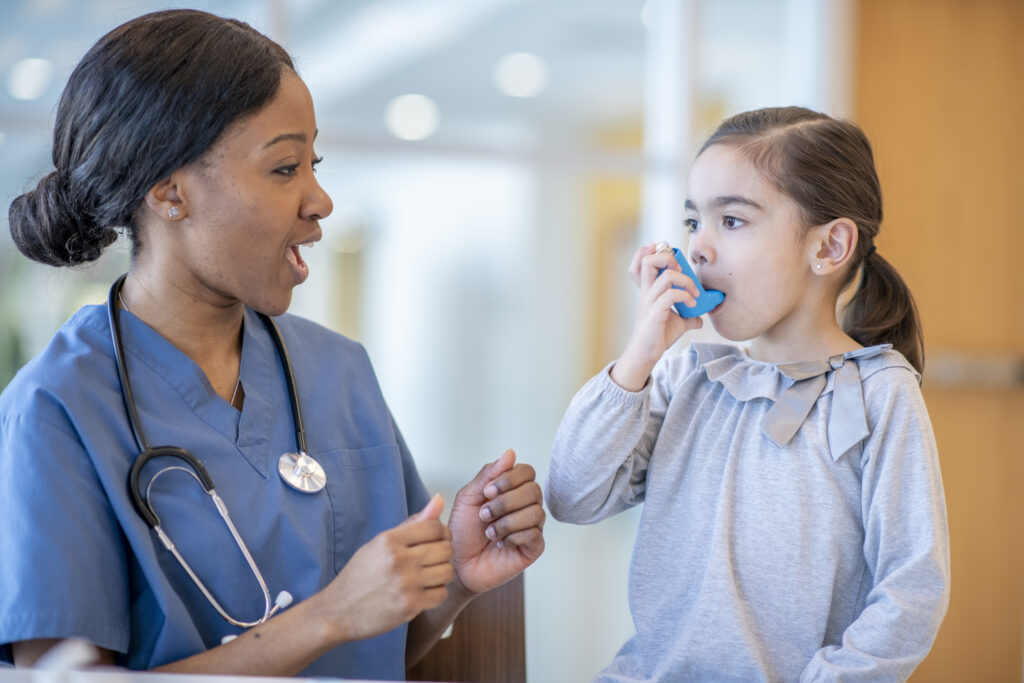 A child using an inhaler next to a doctor