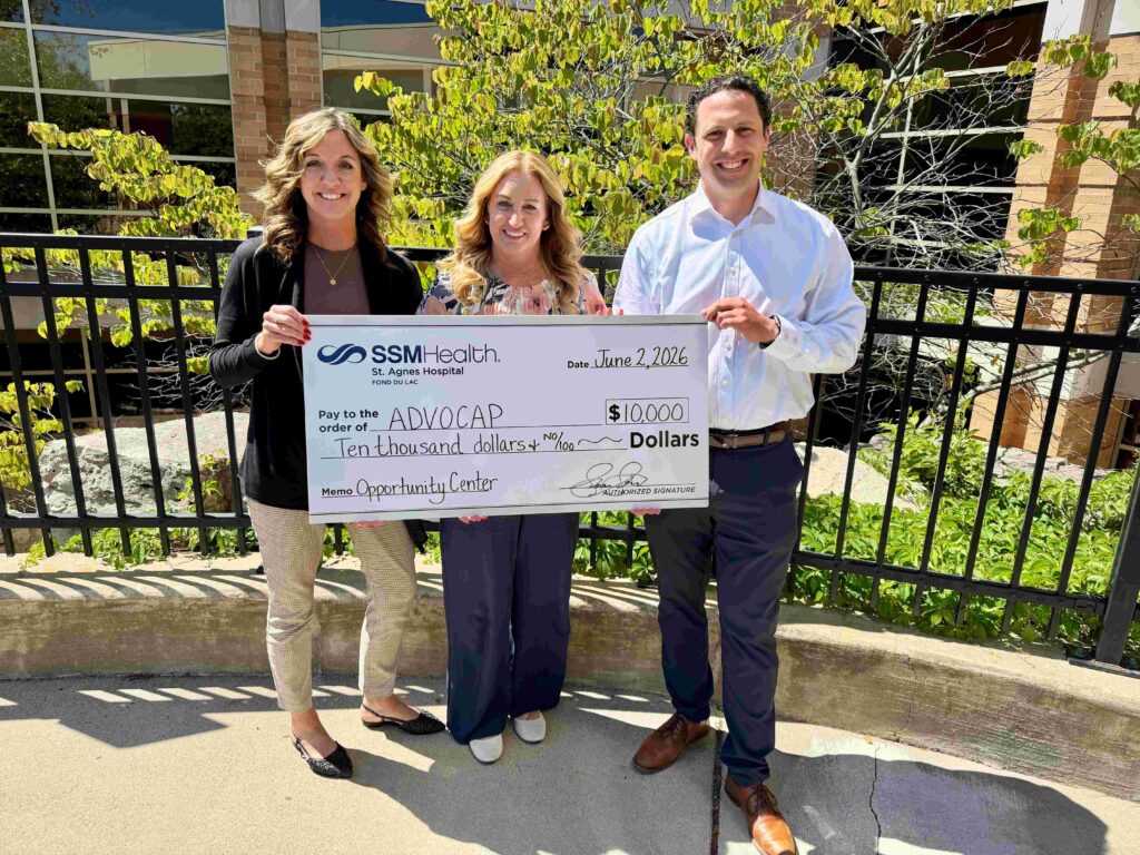 Three people with a big check