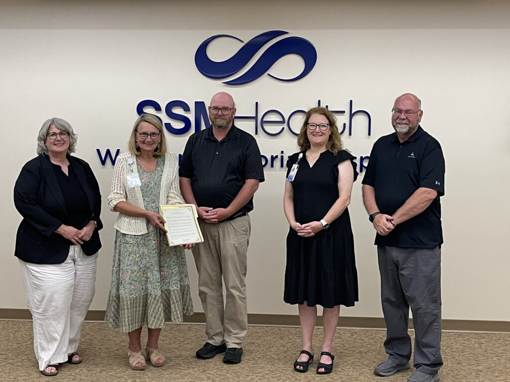 A group of five people and one with a certificate