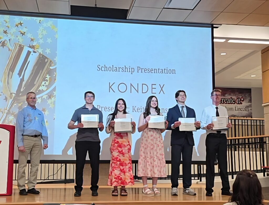 Five high school students with awards on stage