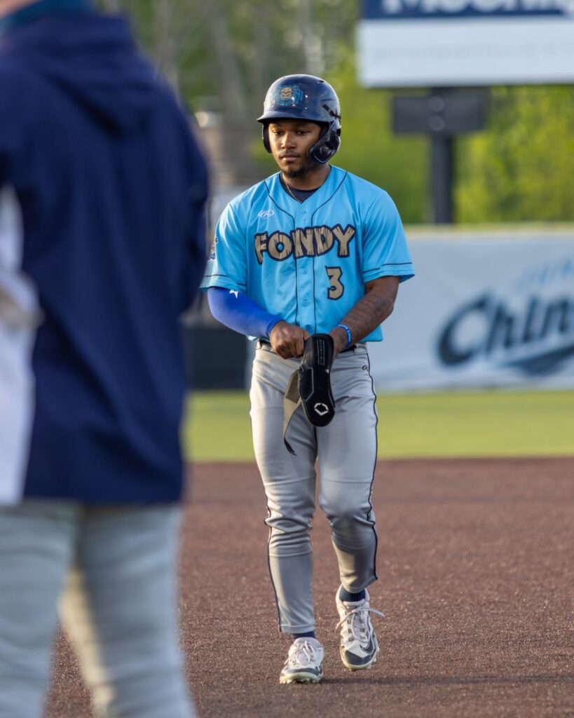A baseball player walking to a base