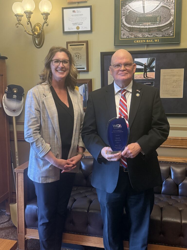A woman and a man holding an award