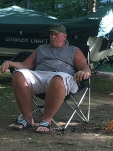 An older man sitting in a lawn chair