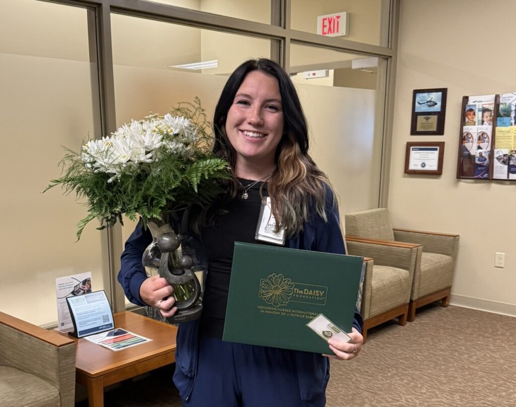 A woman holding flowers and a certificate