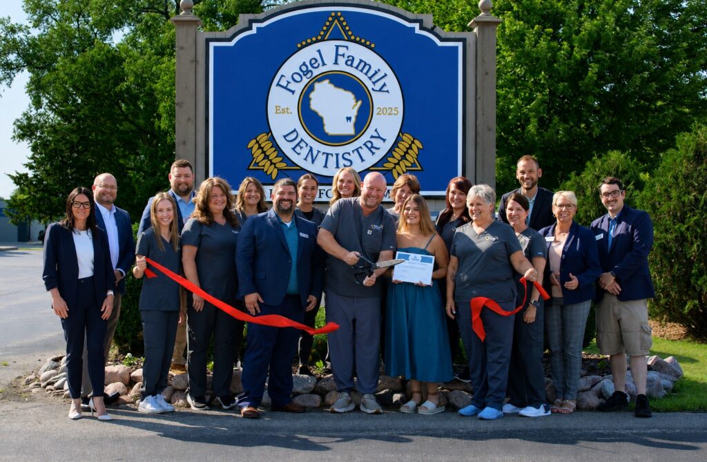 A large group of people outside for a ribbon cutting
