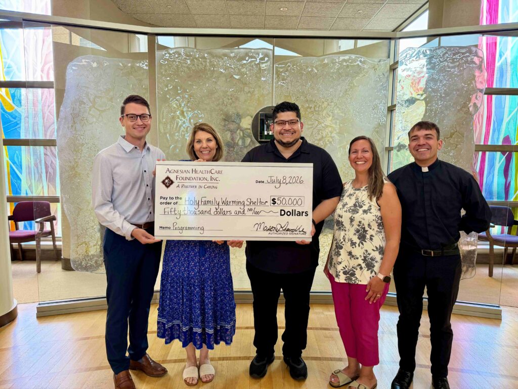 Five people with a big check