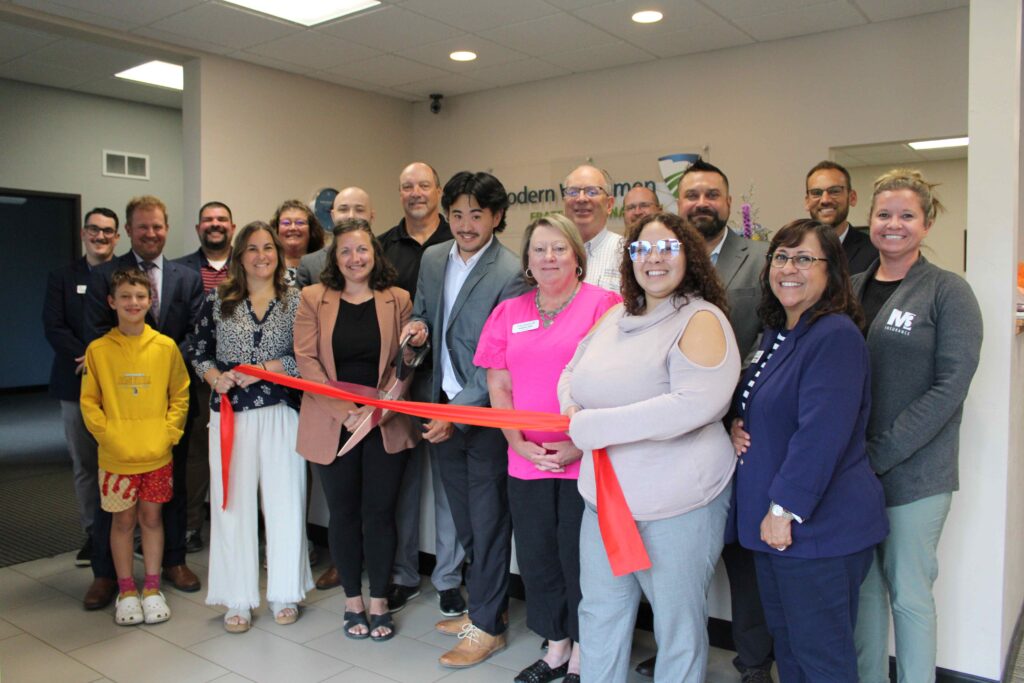 A large group of people inside for a ribbon cutting