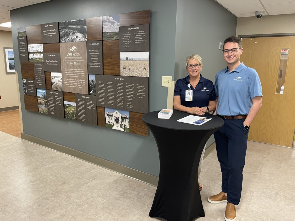A man and a woman standing by a table as a display