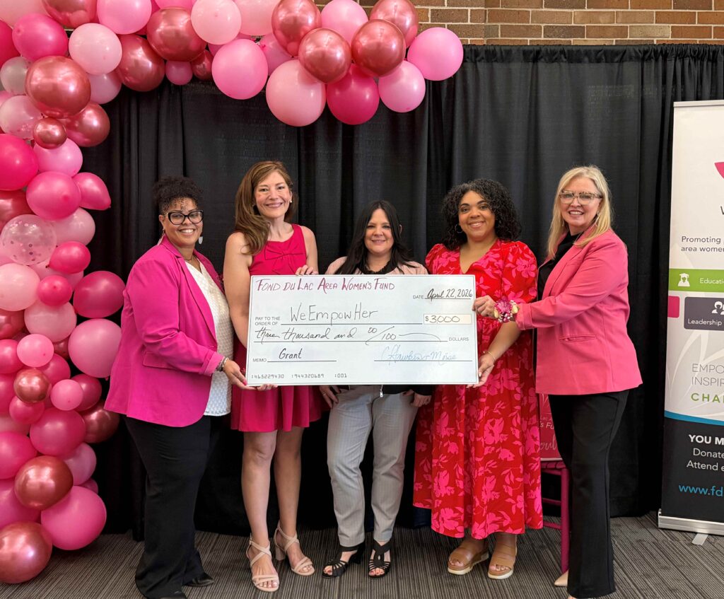 Five women with a big check and pink balloons