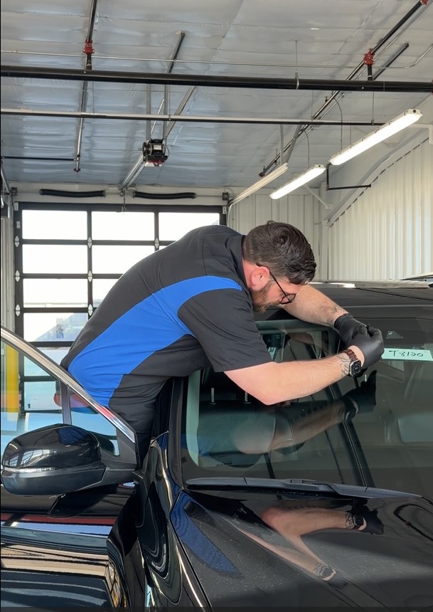 A man repairing a car windshield
