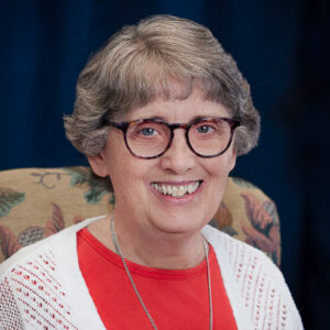 A smiling older woman with glasses