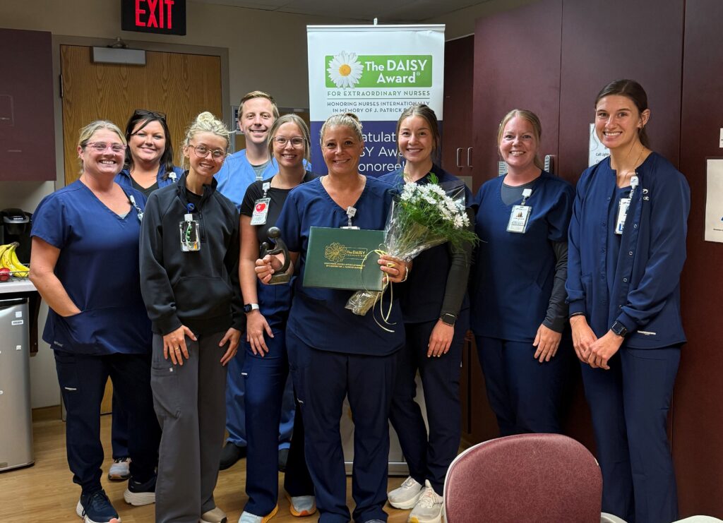 A group inside and one with an award and daisies