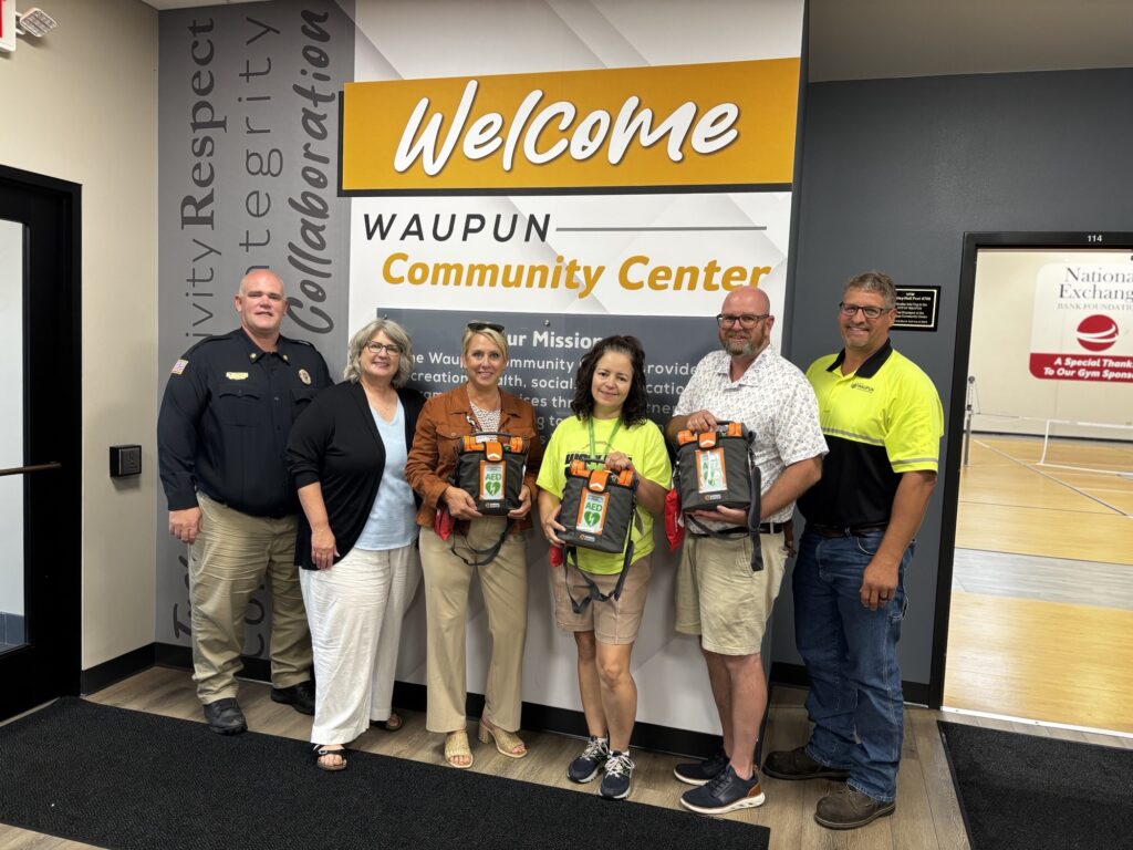 A group of six people, three of whom have AED machines