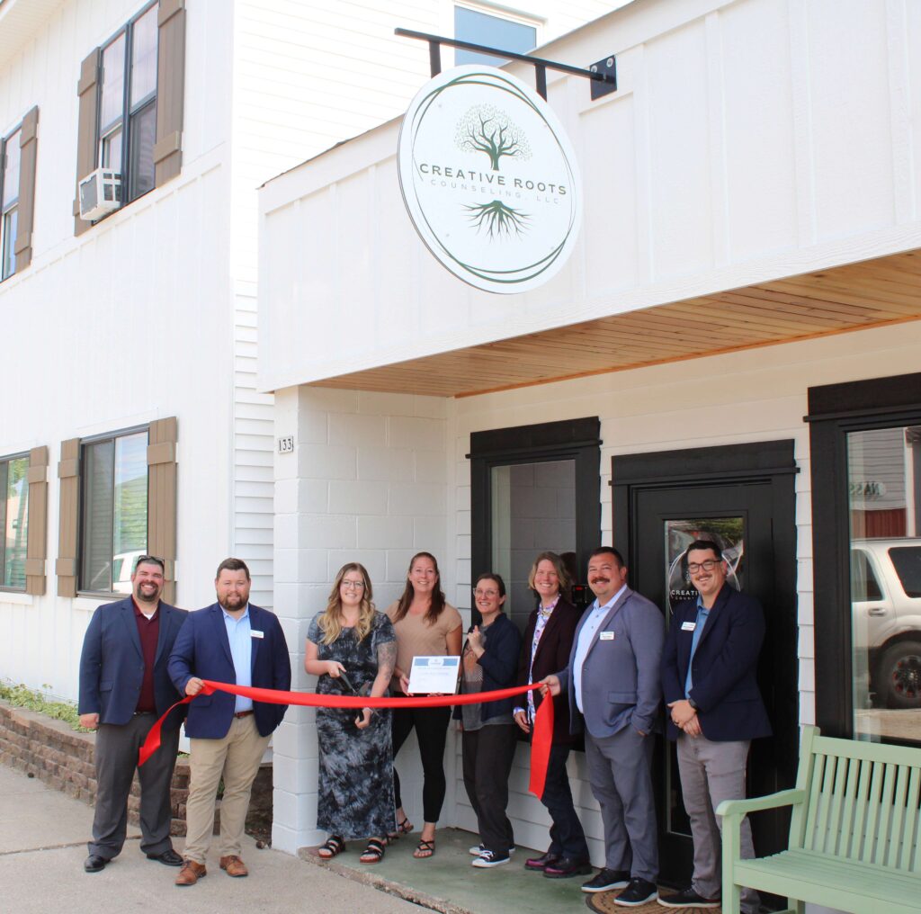 A group of people outside for a ribbon cutting