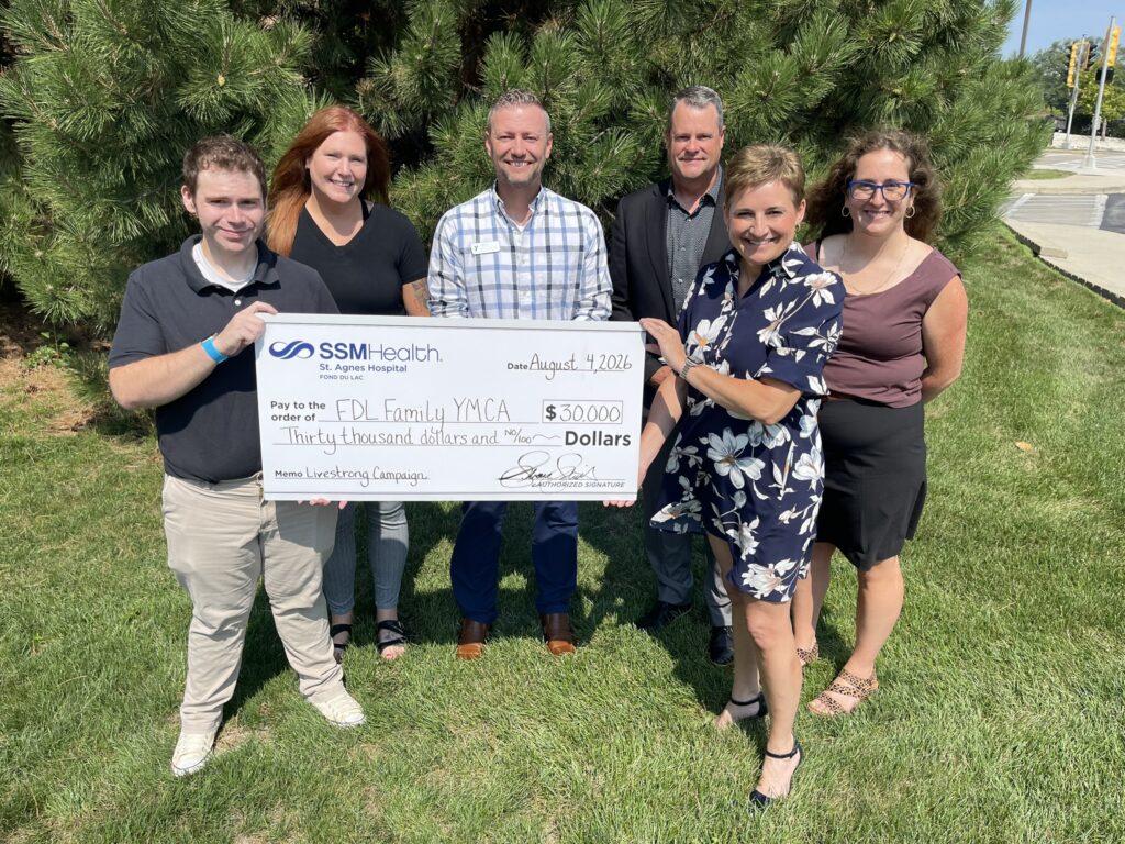 Six people outside with a big check