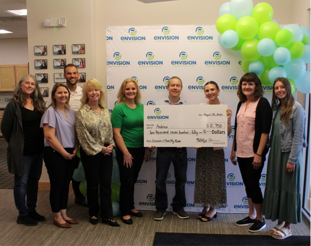 A group of people inside with a big check