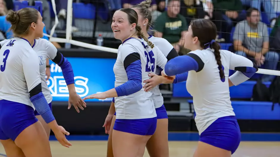 Women playing college volleyball