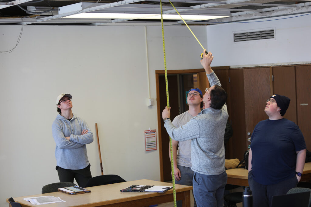 Students in a classroom measuring things.