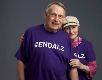 An older man and woman in purple