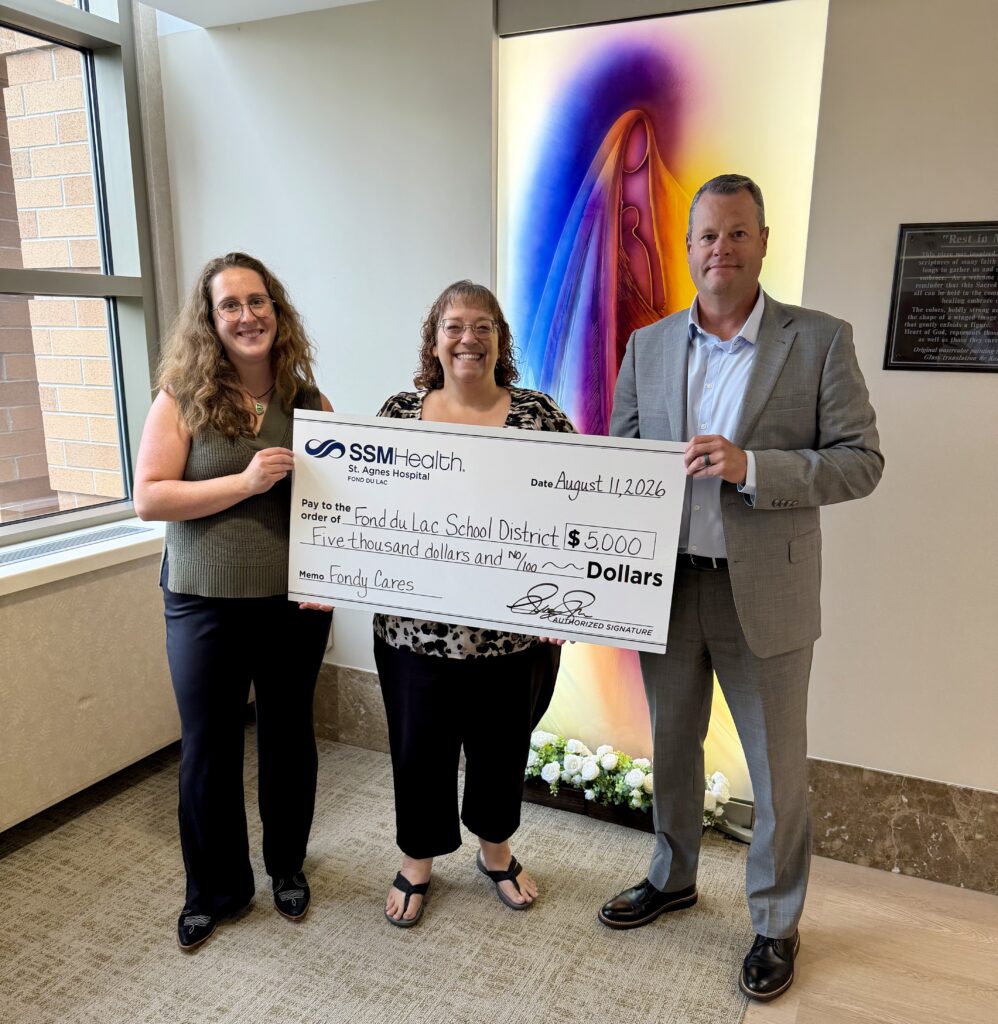 Three people with a big check