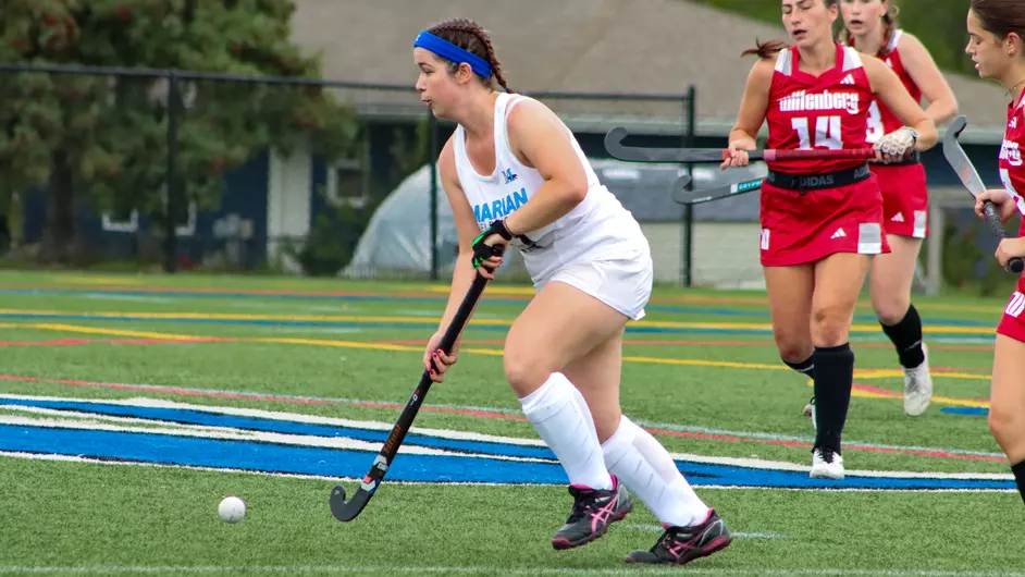Women playing college field hockey