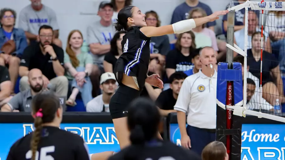 Women playing college volleyball