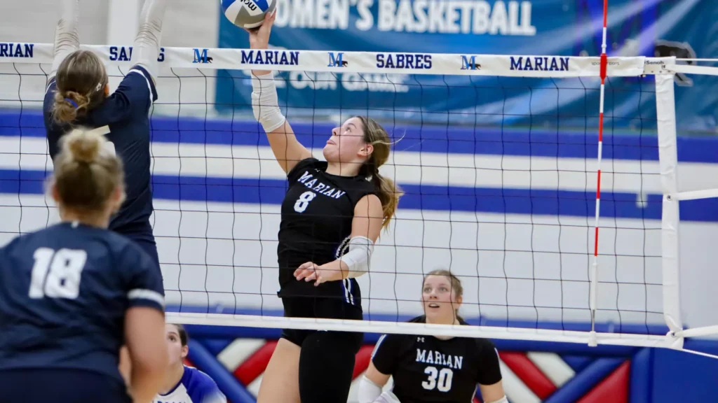 Women playing college volleyball